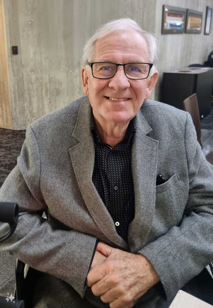 Older gentleman in spectacles relaxing in chair.